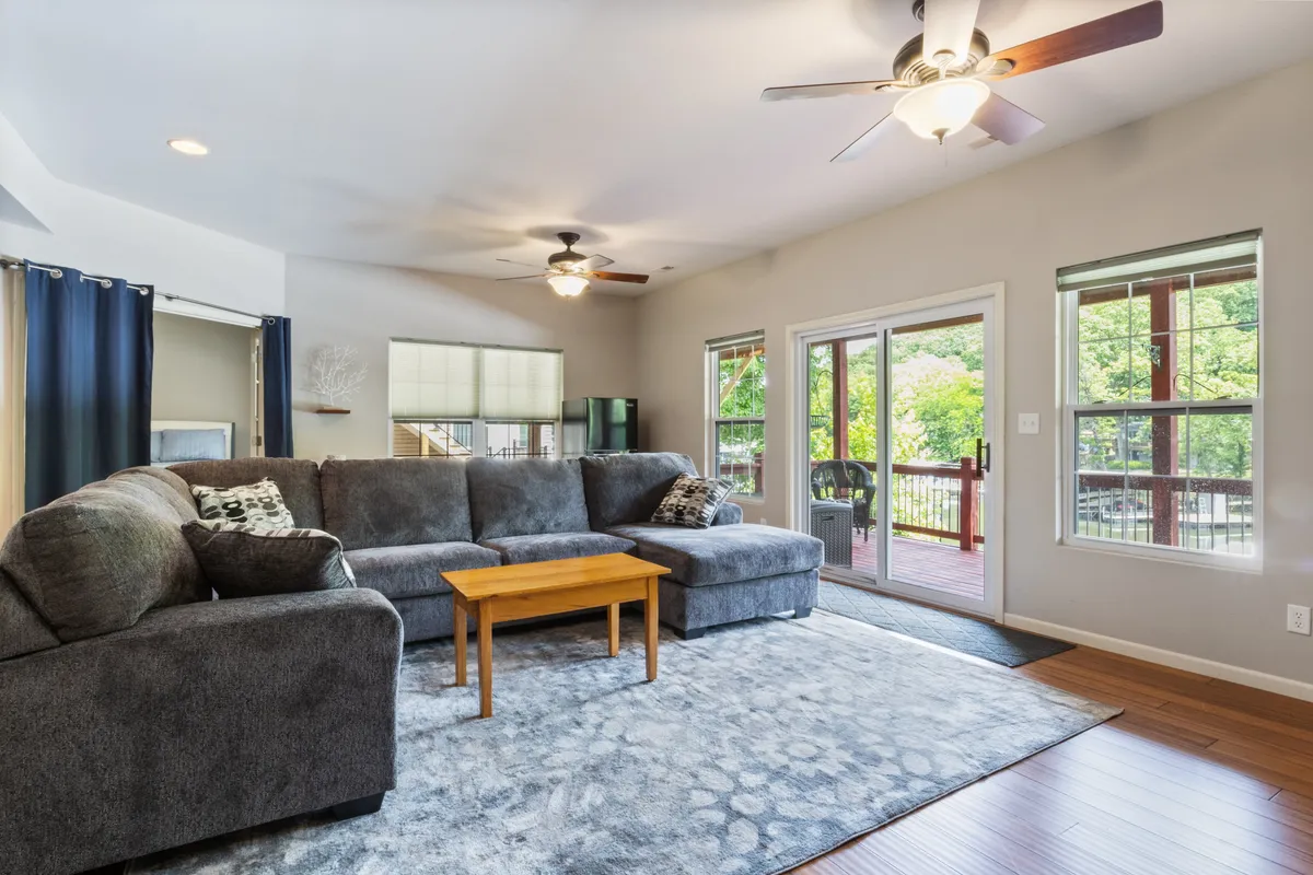 A comfortable living area with large windows that frame inviting views of the outside. The sofa and coffee table create a cozy setting for relaxing after a day of shopping, dining, or exploring, while the windows suggest easy access to and visual connection with the outdoors.